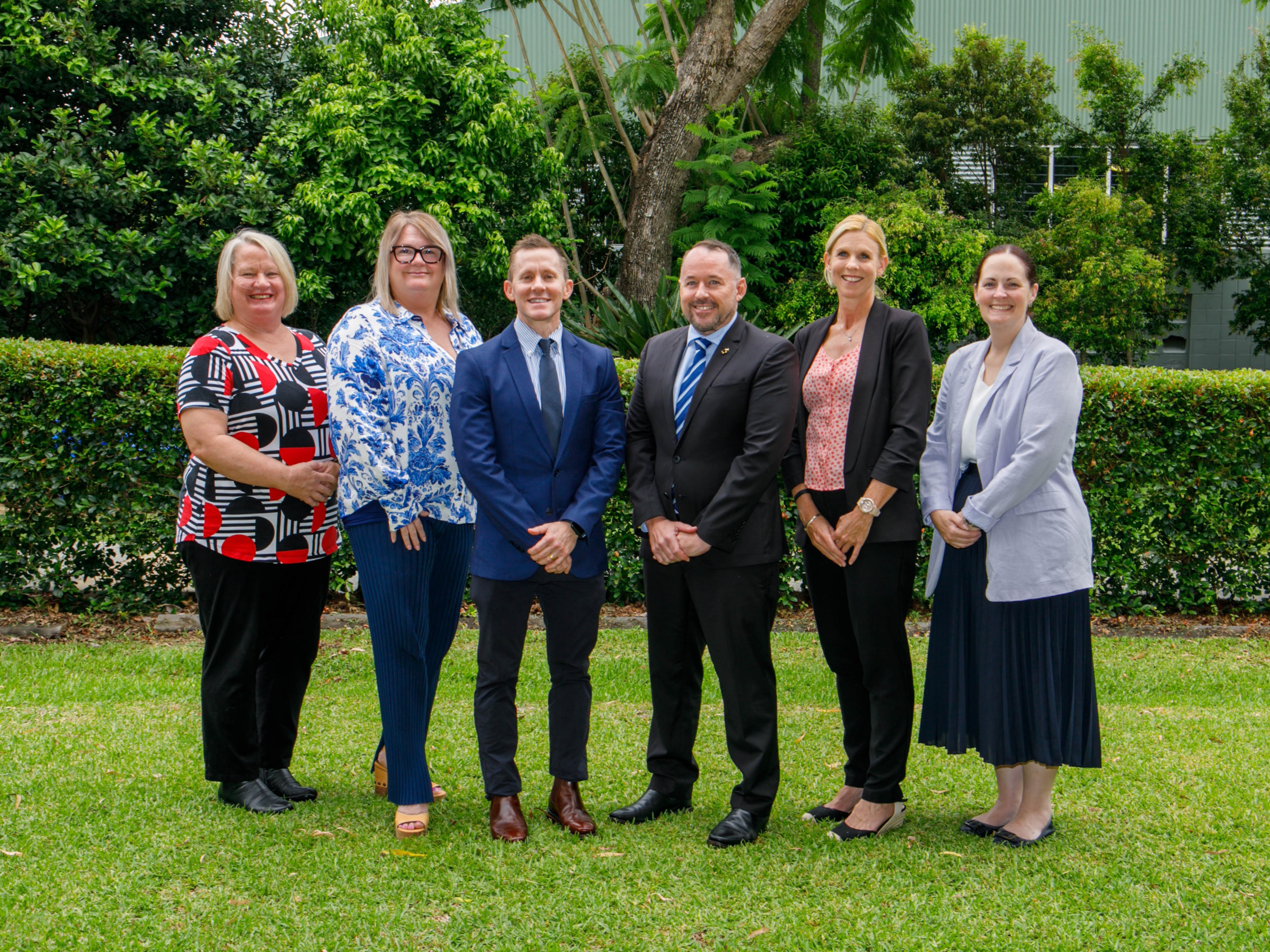 staff group posing together on school grounds, representing leadership and a collaborative school community