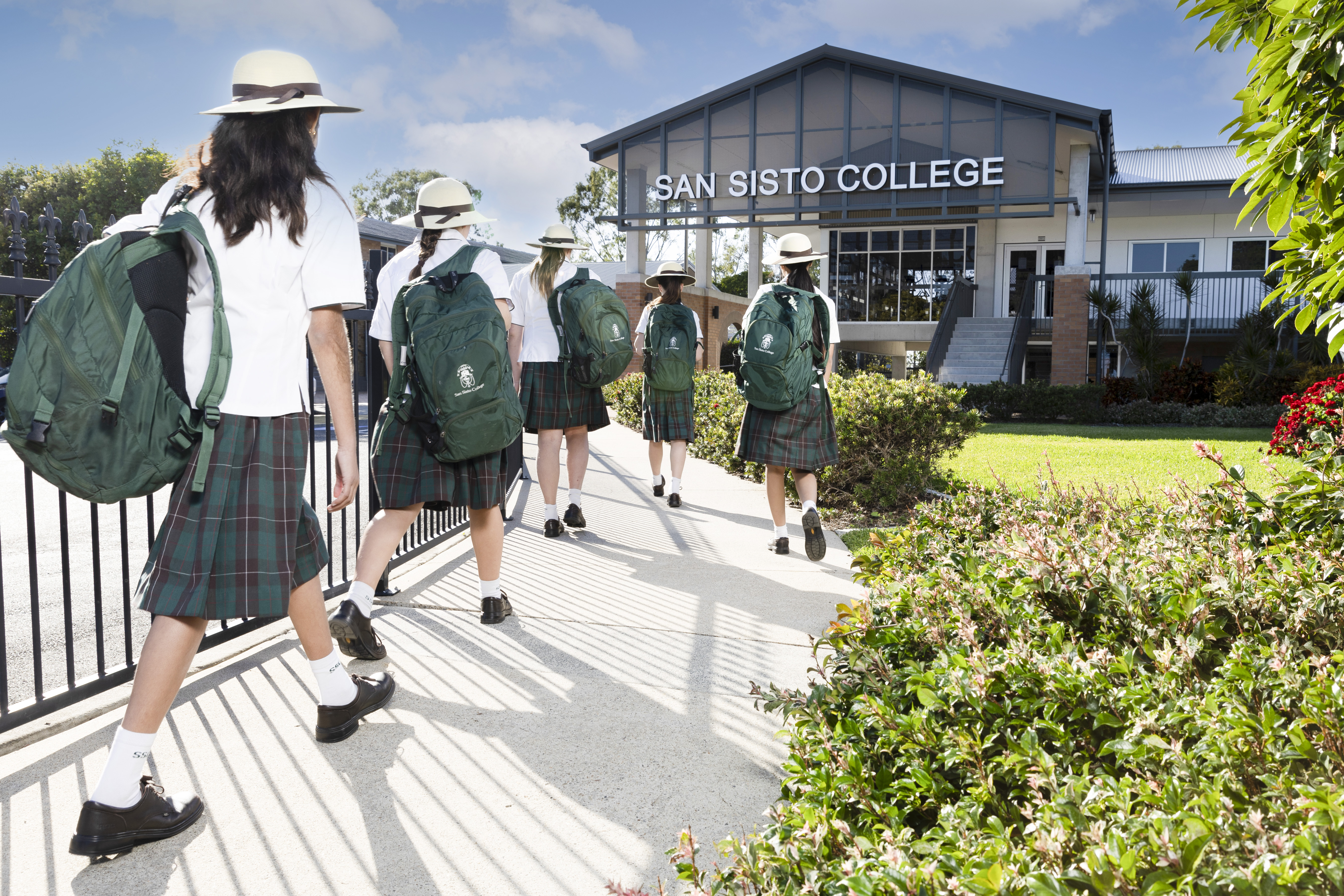 students in school uniform walking together towards campus, representing student journey, belonging and a connected school community