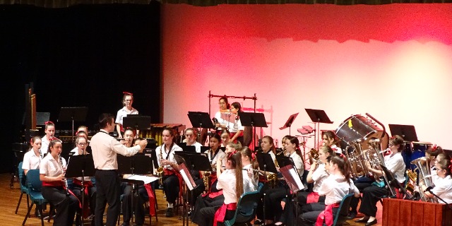 Students performing together in a concert band on stage, highlighting music education teamwork and creative expression at San Sisto College